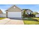 Tan house with a white garage door and manicured lawn at 481 Irees Way, Longs, SC 29568