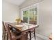 Bright dining area with a wood table and leather chairs, offering a view of the wooded backyard at 1025 Algonquin Dr. # 15-E, Pawleys Island, SC 29585
