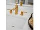 Modern bathroom vanity with gold faucets and white countertop at 8483 Duke Pl. # 36, Myrtle Beach, SC 29572
