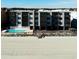 Aerial view of beachfront condo building with pool and ocean access at 814 N Waccamaw Dr. # 311, Garden City Beach, SC 29576