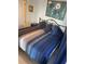 King-size bed with blue bedding in a room with light blue walls and wood flooring at 700 N Waccamaw Dr. # 319, Garden City Beach, SC 29576