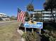 The Beach House at Garden City sign with landscaping, American flag, and building in background at 700 N Waccamaw Dr. # 319, Garden City Beach, SC 29576