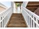 Exterior stairs with white railings leading to a second-story entrance at 4878 Dahlia Ct. # 24-304, Myrtle Beach, SC 29577
