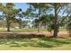 Landscaped golf course with mature trees and residential buildings in the background at 4878 Dahlia Ct. # 24-304, Myrtle Beach, SC 29577