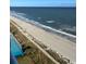 Aerial view of oceanfront property showcasing beach, pool, and dune landscape at 2201 S Ocean Blvd. # 1404, Myrtle Beach, SC 29577