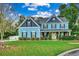 Two-story light blue house with stone accents and landscaping at 713 Shell Point Ct., Longs, SC 29568