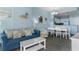 Living room with blue sofa, white coffee table, and adjacent dining area at 300 N Ocean Blvd. # 128, North Myrtle Beach, SC 29582