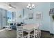 Dining room with white table and chairs, adjacent to living area at 300 N Ocean Blvd. # 128, North Myrtle Beach, SC 29582