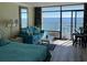 Ocean view living room with teal couch and balcony access at 201 74Th Ave. N # 1134, Myrtle Beach, SC 29572