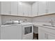 Bright laundry room with white cabinets, washer, and dryer at 7274 Sarteano Dr., Myrtle Beach, SC 29572