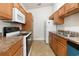 Galley-style kitchen with wood cabinets, white appliances, and granite countertops at 111 Portsmith Dr. # 6, Myrtle Beach, SC 29588