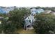 White beach house with large deck and stairs at 114 N Pinewood Dr. N, Surfside Beach, SC 29575