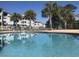Community pool with lounge chairs and palm trees in a sunny area at 4893 Magnolia Pointe Ln. # 103, Myrtle Beach, SC 29577