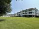 Exterior view of a multi-unit building with grassy area at 4893 Magnolia Pointe Ln. # 103, Myrtle Beach, SC 29577