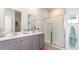 Bathroom with double vanity, gray cabinets, and a shower at 7302 Meadow Walk Loop, Loris, SC 29569