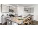 Granite kitchen island with seating, gray cabinets, and stainless appliances at 7335 Meadow Walk Loop, Loris, SC 29569