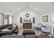 Living room with vaulted ceilings, a fireplace, leather furniture, and an open view to the dining area at 113 Edwards Ln., Longs, SC 29568