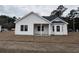 Back view of a new construction home with a covered porch and spacious backyard at 4955 Old State Highway 90, Conway, SC 29526