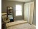 Simple bedroom with a white rocking chair and closet with shutter doors at 1021 Myrtle Dr., Surfside Beach, SC 29575