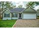 Green house with white garage door and landscaping at 3723 Choppee Rd., Georgetown, SC 29440