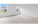 Bright bedroom with neutral carpeting and two large windows at 1127 Nw Rosefield Way, Calabash, NC 28467