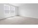 Bright bedroom with neutral carpeting and two windows at 1127 Nw Rosefield Way, Calabash, NC 28467