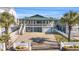 Two-story home with a green roof, white fence, and a driveway at 310 34Th Ave. N, North Myrtle Beach, SC 29582