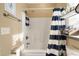 Bathroom with tub shower, striped curtain, and shelving at 6001 - P-29 S Kings Hwy., Myrtle Beach, SC 29575