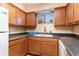 L-shaped kitchen with dark countertops and wood cabinets at 2000 Green Blvd. # 8B, Myrtle Beach, SC 29577