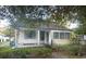 White single story home with a front porch and mature trees at 228 Saint James St., Georgetown, SC 29440