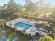 An aerial view of a community pool with a pool house, landscaping, and a canal at 4818 Innisbrook Ct. # 603, Myrtle Beach, SC 29579