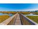 Wooden dock extending over calm water with view of homes at 77 Salt Marsh Circle # 18E, Pawleys Island, SC 29585