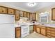 Kitchen with wood cabinets, white appliances, and tile floor at 102 Dorman Circle, Myrtle Beach, SC 29577