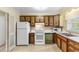 Kitchen with wood cabinets, white appliances, and tile floor at 102 Dorman Circle, Myrtle Beach, SC 29577