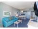 Bright living room with teal sofa, coffee table, and ocean view at 300 N Ocean Blvd. # 1628, North Myrtle Beach, SC 29582