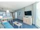 Living room features a teal sofa, coffee table, and access to balcony at 300 N Ocean Blvd. # 1628, North Myrtle Beach, SC 29582