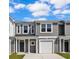 Two-story townhome with gray siding, white garage door, and landscaping at 310 Sandridgebury Dr. # 40, Little River, SC 29566