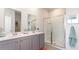 Bathroom with gray double vanity, a large mirror, and a shower at 898 Farmers Passage Loop, Loris, SC 29569