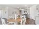 Dining room with round wooden table and white chairs, adjacent to kitchen at 898 Farmers Passage Loop, Loris, SC 29569