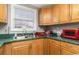 Kitchen boasts wood cabinets, green counters, and a double sink at 6001-1774 S Kings Hwy., Myrtle Beach, SC 29575