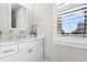 Bathroom with white vanity, marble countertop, and window with shutters at 219 South Seaside Dr., Surfside Beach, SC 29575