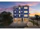 Oceanfront home with lighted windows at sunset, parking and beach access at 219 South Seaside Dr., Surfside Beach, SC 29575