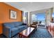 Living room with blue sofa, tan armchair, and ocean view at 5200 N Ocean Blvd. # 833, Myrtle Beach, SC 29577