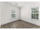 Bright bedroom featuring wood-look flooring and two windows at 6010 Windsor Green Way # 301, Myrtle Beach, SC 29579