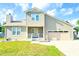 Beige two-story house with a two-car garage and well-maintained lawn at 611 Six Lakes Dr., Myrtle Beach, SC 29588