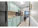 Bright kitchen featuring teal cabinets, stainless steel appliances, and a view to living area at 6804 Ocean Blvd. # 331, Myrtle Beach, SC 29572