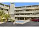 Exterior view of Golf Glen Villas building, showcasing balconies and parking at 1101 Possum Trot Rd. # A103, North Myrtle Beach, SC 29582