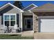 Craftsman style house with gray siding, stone accents, and rocking chairs on the porch at 1178 Pyxie Moss Dr., Little River, SC 29566