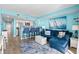 Open living room with coastal decor, blue sofa, and ocean view at 6100 N Ocean Blvd. # 207, North Myrtle Beach, SC 29582