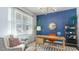 Bright home office featuring a blue accent wall, built-in shelving, and a comfortable sitting area at 724 Wallace Dr., Little River, SC 29566